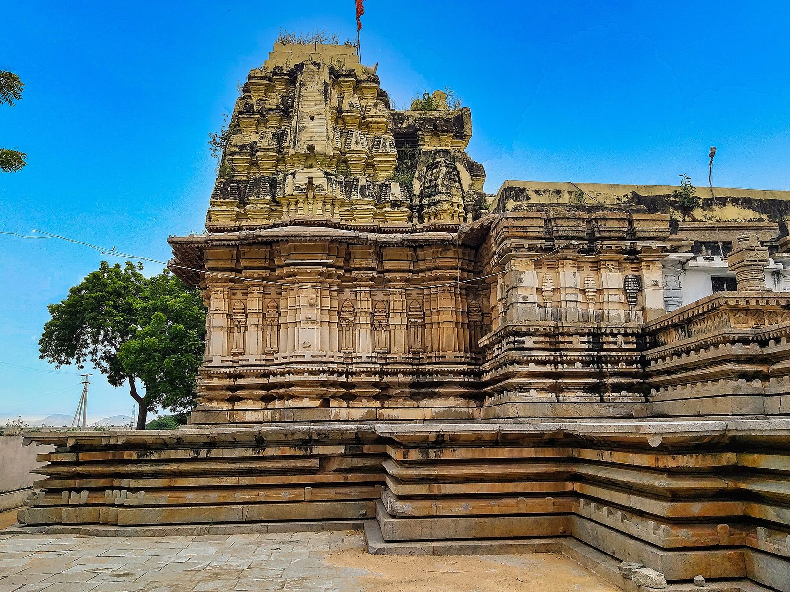The Erakesvara temple at Pillalamarri: a shrine with a tiered superstructure and closely moulded walls on a broad stepped platform, under a deep blue sky