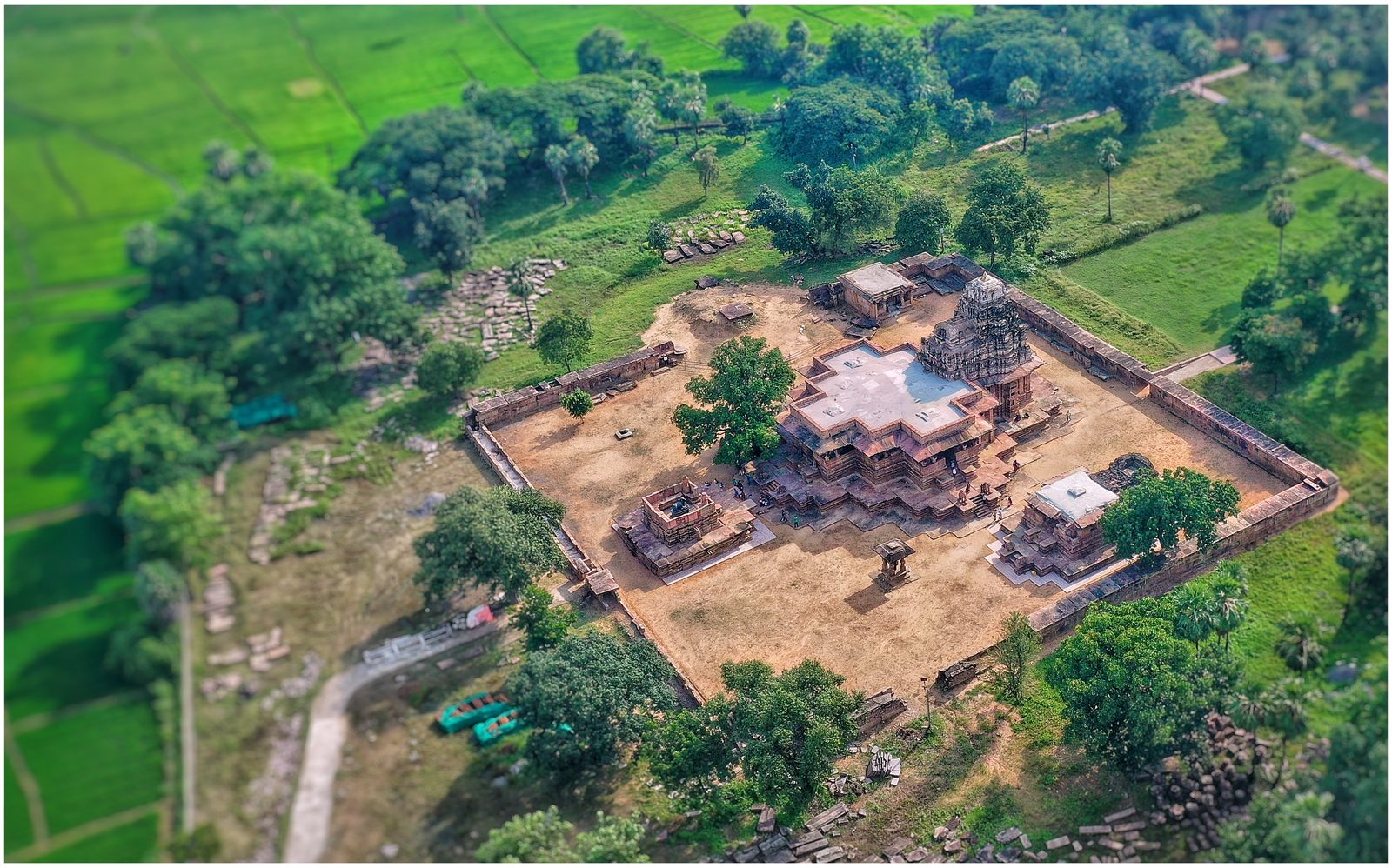Aerial view of the Ramappa temple complex: a rectangular walled enclosure among green fields, with the main temple on its stepped platform with projecting corners near the centre and smaller shrines within the walls